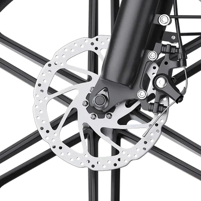 Close-up of a bicycle disc brake with a perforated rotor and black caliper on black spokes